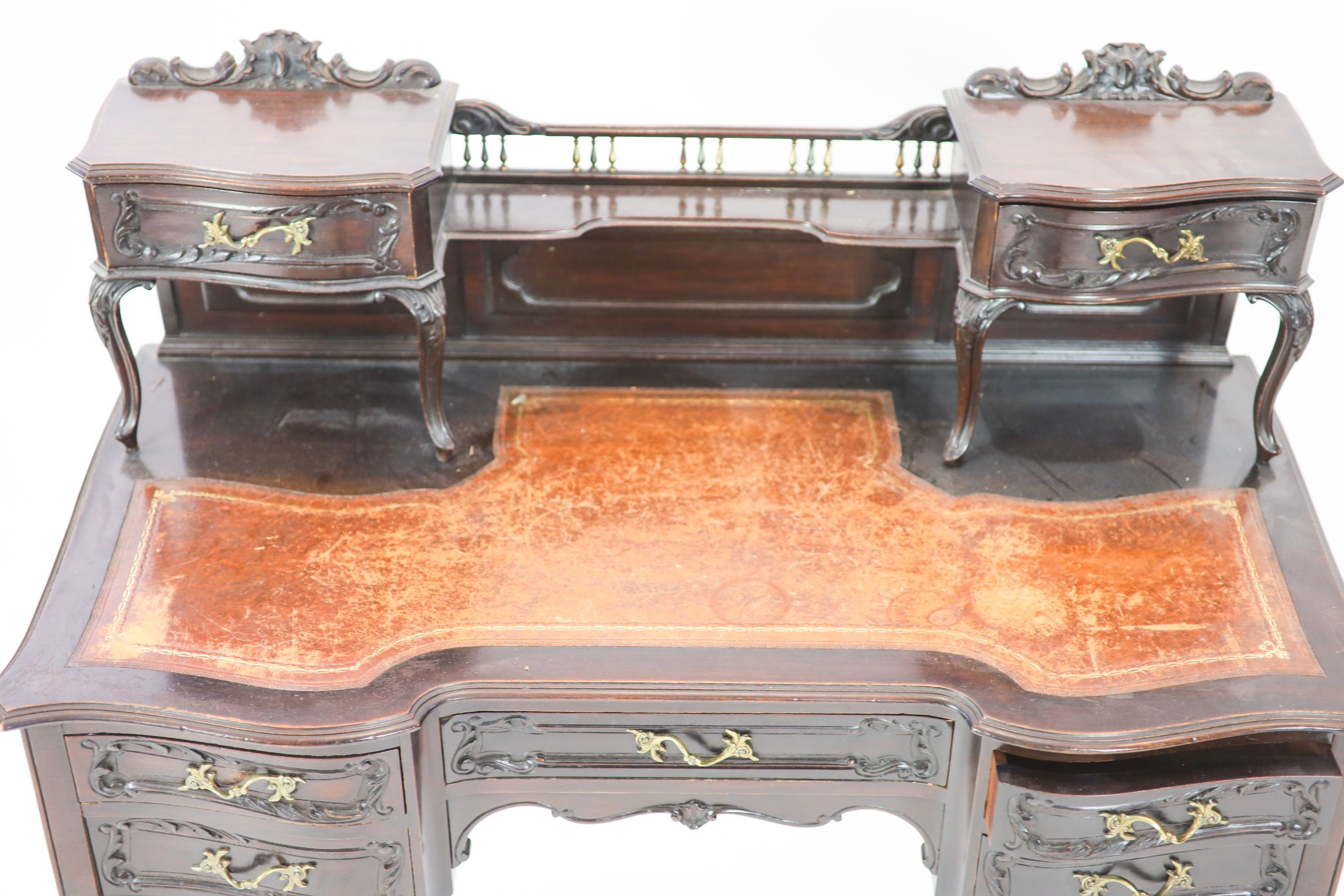 A late Victorian carved mahogany serpentine-shaped writing desk, length 106cm, depth 54cm, height 105cm